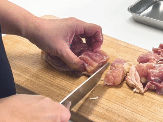 菜切包丁で鶏肉を切る